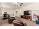 Upstairs living room featuring neutral carpet, a ceiling fan, TV, and two comfortable recliners at 13123 W Cottontail Ln, Peoria, AZ 85383