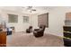 Upstairs living room featuring neutral carpet, ceiling fan, two comfortable leather recliners, and natural light at 13123 W Cottontail Ln, Peoria, AZ 85383