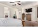 Spacious main bedroom with neutral carpet, a ceiling fan, dresser, closet, and ensuite bathroom at 13123 W Cottontail Ln, Peoria, AZ 85383