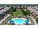 Aerial view of a well-maintained community with a sparkling blue pool, green spaces, and walking paths at 1350 S Greenfield Rd # 1166, Mesa, AZ 85206