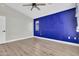 Bedroom features a ceiling fan, wood-look flooring, and a bold accent wall with a bright window at 1350 S Greenfield Rd # 1166, Mesa, AZ 85206