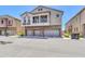 Exterior view of a multi-story townhome with three-car garage, stone accents, and private balconies at 1350 S Greenfield Rd # 1166, Mesa, AZ 85206