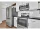 Modern kitchen appliances, stainless steel refrigerator, oven, microwave, and black countertop at 1350 S Greenfield Rd # 1166, Mesa, AZ 85206