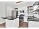 Bright kitchen featuring stainless steel appliances, a center island with granite countertop, and open wooden shelving at 1350 S Greenfield Rd # 1166, Mesa, AZ 85206