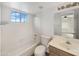 A bright bathroom featuring a shower-tub, tiled wall, vanity, and natural light at 14235 W Shawnee Trl, Surprise, AZ 85374