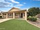 Exterior of the home with a covered patio, artificial lawn, and well-maintained landscaping at 14235 W Shawnee Trl, Surprise, AZ 85374
