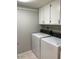 Functional laundry room with overhead cabinets and full-sized washer and dryer units at 1432 W Emerald Ave # 51, Mesa, AZ 85202