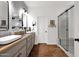 Well-lit bathroom featuring double sink, modern shower, and brick floor at 1462 E Sweet Citrus Dr, Queen Creek, AZ 85140