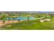 Panoramic aerial view of a lush golf course featuring pristine greens, a tranquil lake, and scenic desert landscaping at 1462 E Sweet Citrus Dr, Queen Creek, AZ 85140