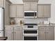 Close up of updated kitchen featuring stainless steel appliances and stylish gray cabinets at 1462 E Sweet Citrus Dr, Queen Creek, AZ 85140
