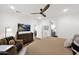 Comfortable main bedroom featuring a ceiling fan, TV, and access to the en suite bathroom at 1462 E Sweet Citrus Dr, Queen Creek, AZ 85140