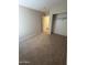 An empty bedroom featuring neutral carpet and a closet at 1546 W Vaughn Ave, Gilbert, AZ 85233