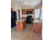The kitchen features wood cabinetry, island, tile floors, and stainless steel appliances at 1546 W Vaughn Ave, Gilbert, AZ 85233