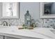 Bathroom featuring double sinks, hexagon tile backsplash, and decorative accents on a marble countertop at 1638 N Avoca --, Mesa, AZ 85207