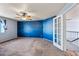 Spacious bedroom featuring two-tone walls, a ceiling fan, neutral carpet, and an exterior door at 1638 N Avoca --, Mesa, AZ 85207
