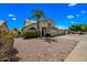 Front exterior view of the home showing the desert landscaping, three-car garage and palm tree at 1638 N Avoca --, Mesa, AZ 85207