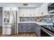 Updated kitchen with stainless refrigerator, white uppers and grey lowers, and tiled backsplash at 1638 N Avoca --, Mesa, AZ 85207