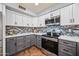 Updated kitchen with tiled backsplash, stainless appliances, grey lowers and white upper cabinets at 1638 N Avoca --, Mesa, AZ 85207