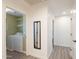 Hallway with mirror and view into laundry room with washer and dryer at 1851 E Ellis St, Phoenix, AZ 85042