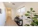 Hallway with a table with flower decorations, natural lighting, and wood floors at 1851 E Ellis St, Phoenix, AZ 85042