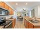 Open kitchen with stainless steel appliances and wood cabinets overlooking a living and dining area at 1851 E Ellis St, Phoenix, AZ 85042