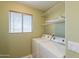 Laundry room with washer, dryer, shelving and window providing natural light at 1851 E Ellis St, Phoenix, AZ 85042
