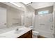 Bathroom with updated vanity, large mirror, and updated bathtub and shower at 2005 Leisure World --, Mesa, AZ 85206