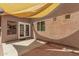 Back patio with a light shade-sail cover, a white door and window frames, and exterior brick-textured walls at 2025 S 83Rd Dr, Tolleson, AZ 85353