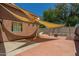 View of a large backyard that includes a light shade-sail cover, brick flooring, fire pit, and perimeter wall at 2025 S 83Rd Dr, Tolleson, AZ 85353