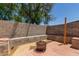 Brick-floored backyard features a built-in bench, block wall, firepit, and mature shade trees overhead at 2025 S 83Rd Dr, Tolleson, AZ 85353