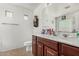 Well-lit bathroom featuring a wood vanity, generous countertop space, and neutral tiling at 2025 S 83Rd Dr, Tolleson, AZ 85353