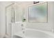 Bright bathroom featuring a soaking tub with separate shower and a frosted window for privacy at 2025 S 83Rd Dr, Tolleson, AZ 85353
