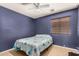 Bedroom with dark blue walls, a fan, and a large window at 2025 S 83Rd Dr, Tolleson, AZ 85353