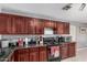 Efficient kitchen offering cherry cabinets, black appliances, and a convenient layout at 2025 S 83Rd Dr, Tolleson, AZ 85353