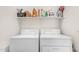 Bright laundry area featuring a white washer and dryer, plus convenient overhead storage shelf at 2025 S 83Rd Dr, Tolleson, AZ 85353