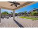 Gorgeous covered patio with ceiling fan, brick pavers, inviting fire pit, and landscaped yard at 20644 W Mariposa St, Buckeye, AZ 85396