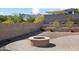 Beautiful backyard featuring a modern fire pit, stone patio, and desert landscaping at 20644 W Mariposa St, Buckeye, AZ 85396