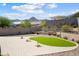 Landscaped backyard showcasing a putting green, desert plants, and mountain views at 20644 W Mariposa St, Buckeye, AZ 85396