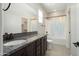 Bathroom featuring a vanity with granite countertop, large mirror, and a shower and tub behind a curtain at 20644 W Mariposa St, Buckeye, AZ 85396