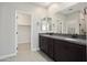 Bathroom featuring a dual sink vanity with granite countertop, large mirror and a walk-in closet at 20644 W Mariposa St, Buckeye, AZ 85396