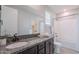 Bathroom with granite countertop, dark brown cabinetry, large mirror, and shower/bathtub combo at 20644 W Mariposa St, Buckeye, AZ 85396