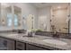 Ensuite double vanity with bronze fixtures, granite countertop, and view of the walk-in shower at 20644 W Mariposa St, Buckeye, AZ 85396