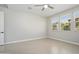 Bright bedroom with neutral tile flooring, ceiling fan, and a pair of window bringing in natural light at 20644 W Mariposa St, Buckeye, AZ 85396