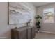 Contemporary bedroom decor with wooden dresser, vases, artwork, and a leafy plant at 20644 W Mariposa St, Buckeye, AZ 85396