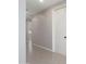 A well-lit hallway features neutral-toned walls, tile flooring, and doors leading to other rooms of the home at 20644 W Mariposa St, Buckeye, AZ 85396