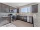 Well-lit kitchen featuring granite countertops, stainless steel appliances, and dark brown cabinets at 20644 W Mariposa St, Buckeye, AZ 85396