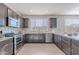 Well-lit kitchen featuring granite countertops, stainless steel appliances, and dark brown cabinets at 20644 W Mariposa St, Buckeye, AZ 85396