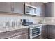 Kitchen featuring granite countertops, stainless steel appliances, and dark brown cabinets at 20644 W Mariposa St, Buckeye, AZ 85396