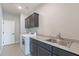 Functional laundry room with a modern washer and dryer, gray cabinets, and a sink for added convenience at 20644 W Mariposa St, Buckeye, AZ 85396