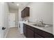 This laundry room boasts a stainless sink, a washer and dryer, and dark wood cabinets above at 20644 W Mariposa St, Buckeye, AZ 85396
